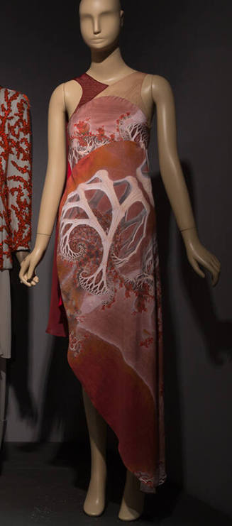 Halter neck dress with geometric print of shades of pink and red and asymmetrical hemline from …