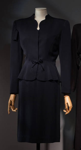 Navy blue suit:  jacket with scallop cut V-neck, shoulder pads, and below knee length straight …