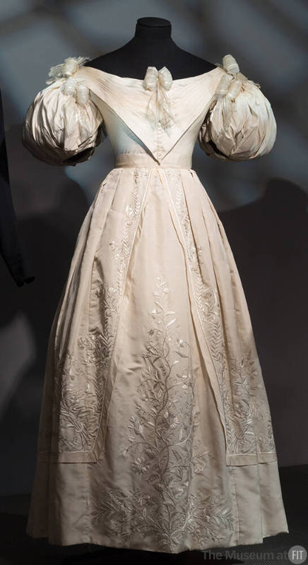 Ivory evening dress with short puff sleeves, full skirt with stitch embroidery, ribbon bows att…