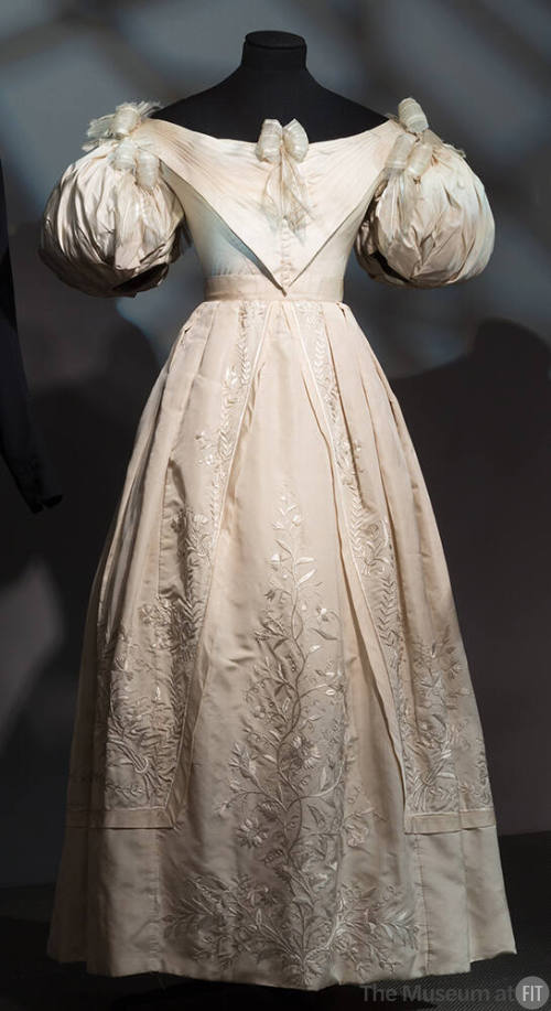 Ivory evening dress with short puff sleeves, full skirt with stitch embroidery, ribbon bows att…