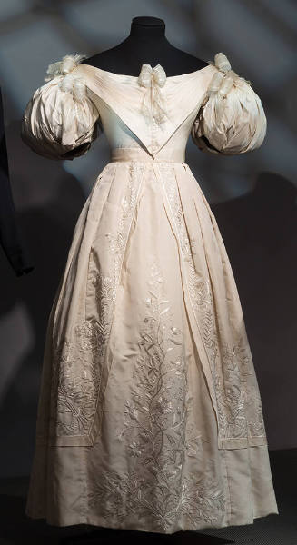 Ivory evening dress with short puff sleeves, full skirt with stitch embroidery, ribbon bows att…