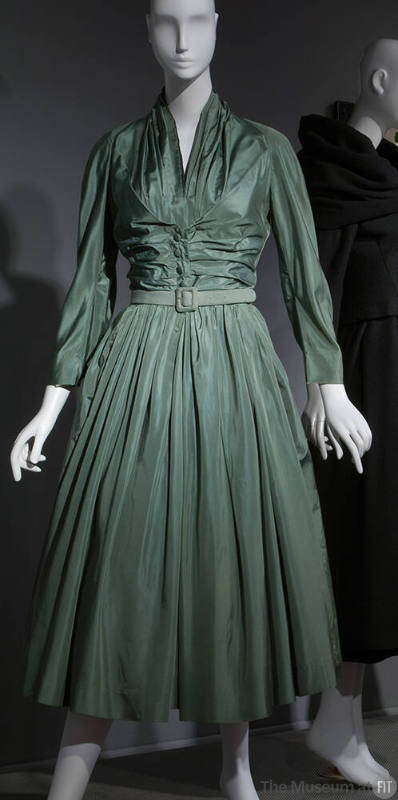 Green silk calf-length dress with stylized shirtwaist, ruching at center bodice, full skirt and…