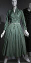 Green silk calf-length dress with stylized shirtwaist, ruching at center bodice, full skirt and…