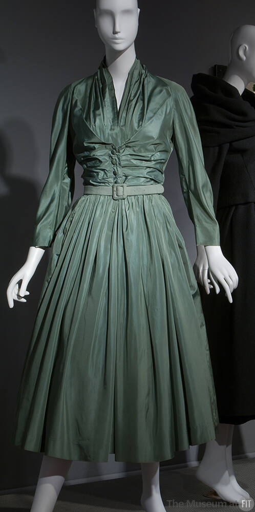 Green silk calf-length dress with stylized shirtwaist, ruching at center bodice, full skirt and…