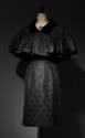 Dotted black cocktail dress and matching capelet with black velvet collar, button closure and s…