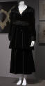 Black velvet suit of knee length jacket with sailor collar, braid trim at high waist and cuffs …