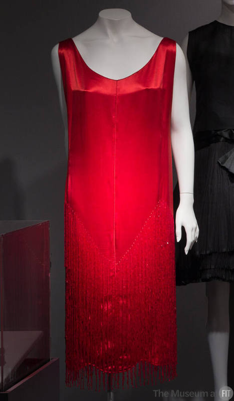 Sleeveless red chemise dress with red bugle bead fringe in v-shapes at skirt; scoop neck