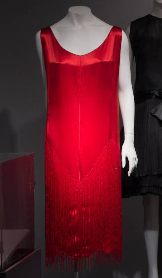 Sleeveless red chemise dress with red bugle bead fringe in v-shapes at skirt; scoop neck