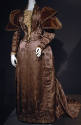 Mauve brocade floor length dress; cream bodice panel; voluminous velvet cap shoulder long sleev…