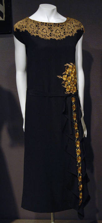 Black cap sleeve dress with wide lace collar, embroidered flowers at hip and down skirt ruffle 