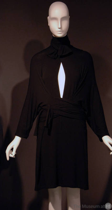 Short black pullover wrap dress, tie collar on deep slit neck, long batwing sleeves, attached w…