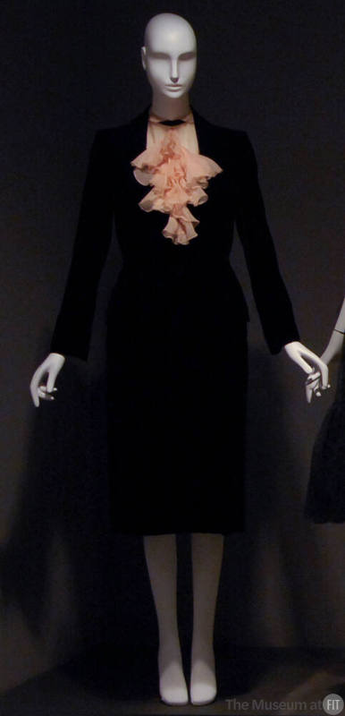 Black suit and pale pink blouse with ruffled collar 