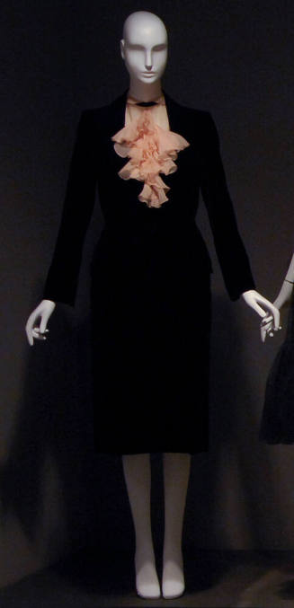 Black suit and pale pink blouse with ruffled collar 