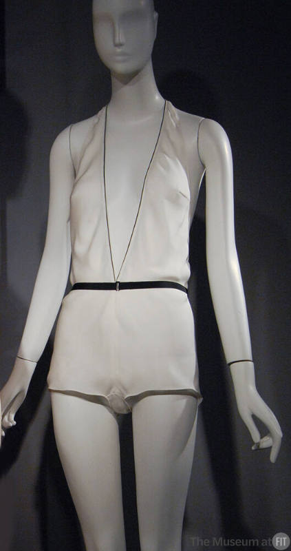 Off-white halter style boy short teddy with plunging V-neck, black edging and black ribbon belt