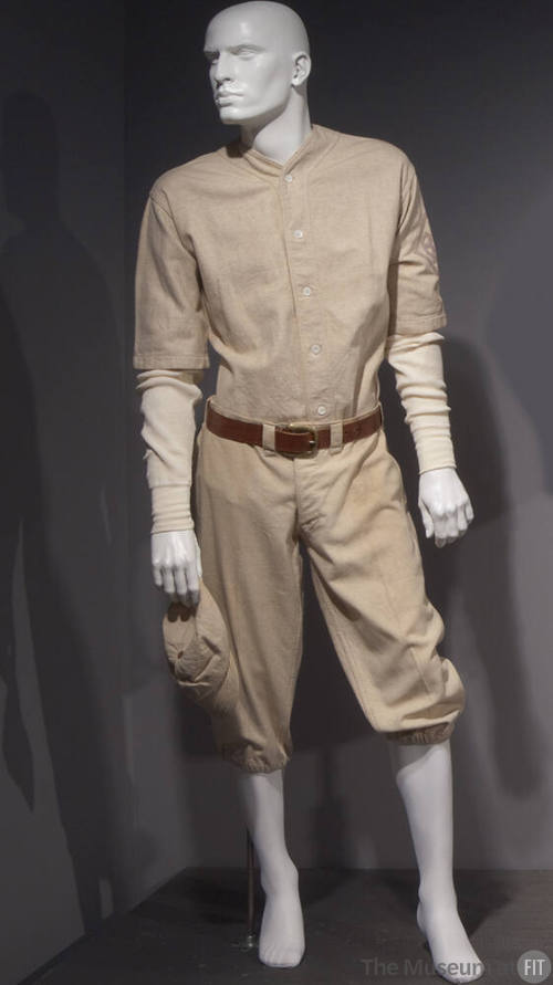 Man’s white baseball uniform of collarless elbow-length button front shirt with a long sleeve s…