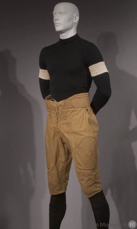 Man’s yellow football knickers with high waist and padding dressed with black long sleeve shirt…