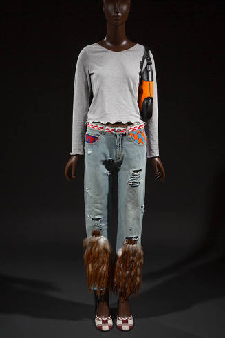 Ensemble of grey long sleeve top, distressed blue jeans with brown feathers at lower leg, orang…