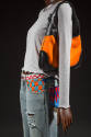 3/4  view of grey shirt ensemble showing geometric multicolor beading on waistline and pockets …