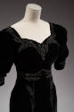 Detail view of black dress bodice showing silver beaded wheat stalks on sweetheart neckline, ar…