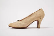 Side view of cream faille pump with large rhinestone
