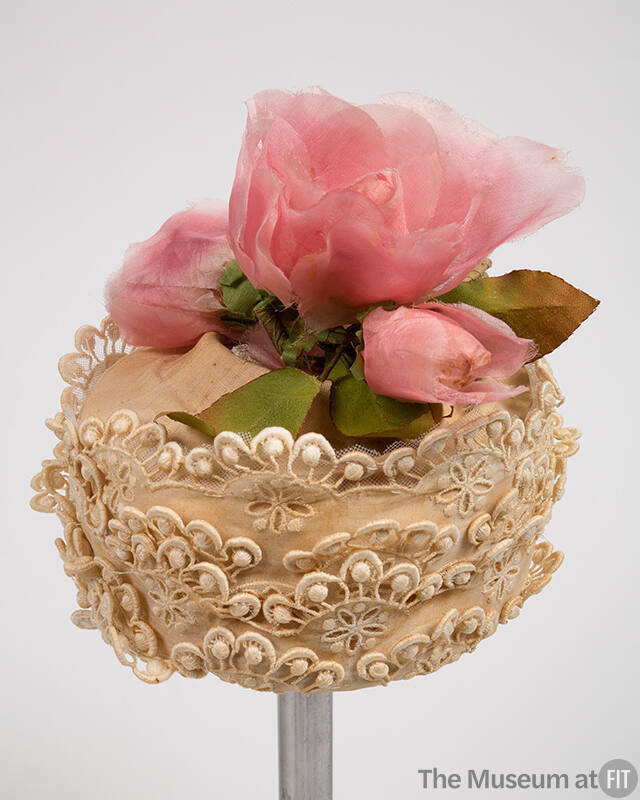 Off-white lace hat with large pink silk flower on crown 