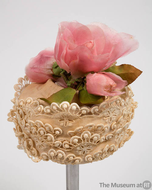 Off-white lace hat with large pink silk flower on crown 