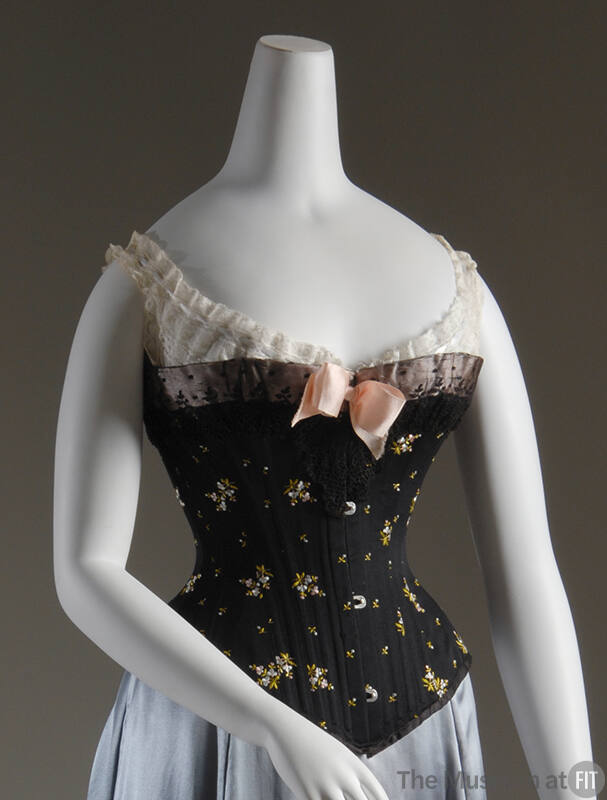 Strapless black corset with blue and green floral embroidery, black lace trim, pink bow at cent…