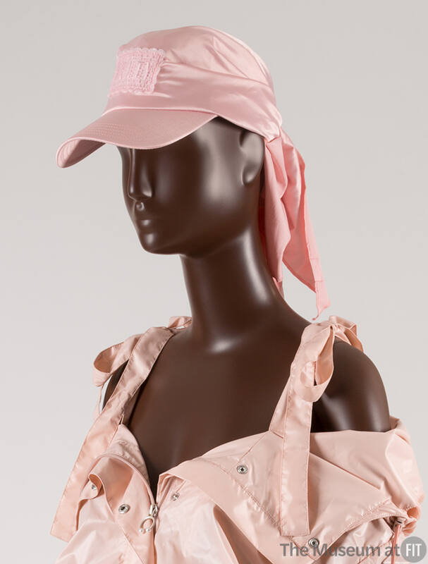 Detail view of pink baseball cap with embroidered patch on front and neck flap with pink nylon …
