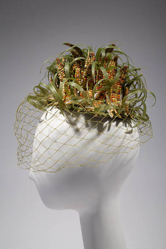 Small hat in the shape of multiple ears of corn and husks with green net face veil