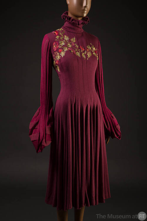 Red knit dress with long gathered sleeves, high turtleneck, embroidered flowers at chest, gathe…
