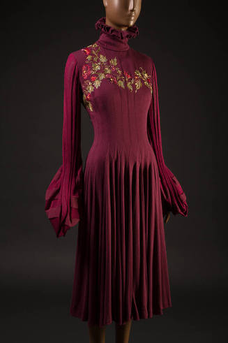 Red knit dress with long gathered sleeves, high turtleneck, embroidered flowers at chest, gathe…