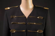 Detail of black jacket embellished with gold metal forks, spoons, and knives
