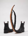 Alternate view of black leather boots with black pull loops and long upturned curled pointed to…