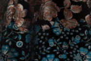 Detail of orange and silver rose pattern and blue and silver floral brocade fabric 