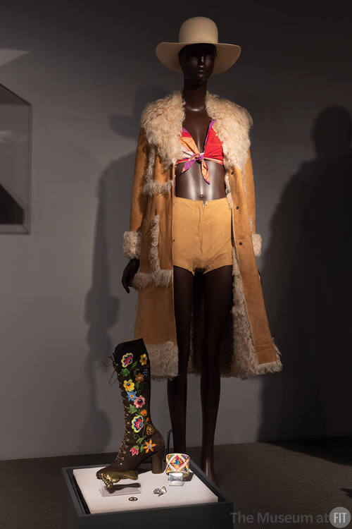 Stephen Burrows coat and printed top, 1971, white hat, circa 1973, and Halston shorts, circa 1971, with accessories by Shoe Biz at Bendel, Giorgio di Sant’Angelo for Calderon, and unidentified designers, circa 1960-circa 1970