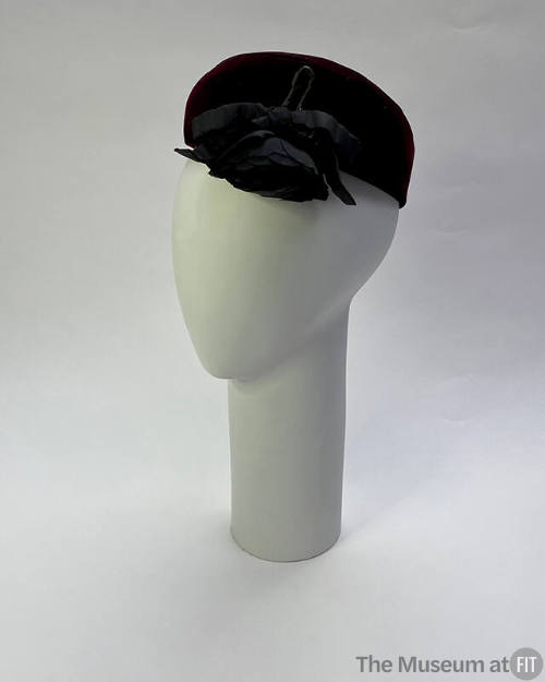Black bumper crown beret with black rose over left eye