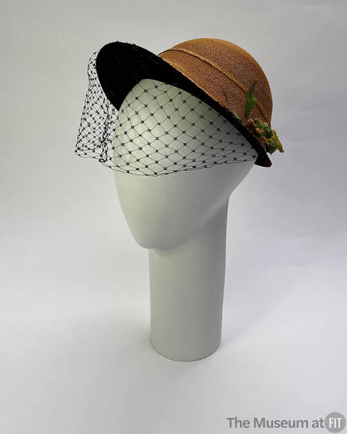 Cloche in natural straw braid with underbrim and band of black velvet, trimmed with moss green …