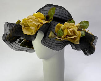 Black horsehair braid hat with large yellow roses and green leaves throughout wide fluted brim