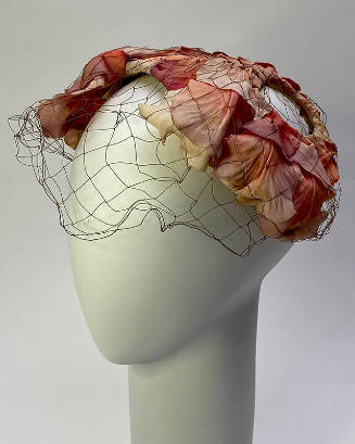 Sculptured hat made of purple and pink rose petals with black net face veil