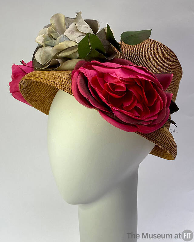 Tan straw hat with two large pink silk roses and one large blue rose in center