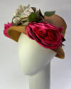 Tan straw hat with two large pink silk roses and one large blue rose in center