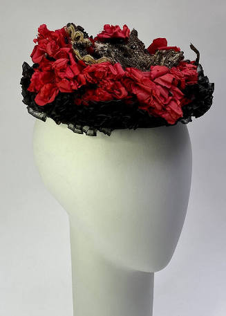 Saucer hat, decorated with gilt thread, silver sequins, and red fabric flowers
