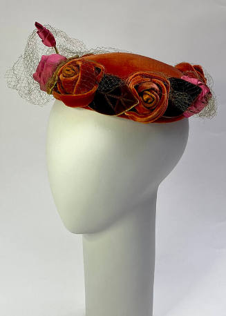 Red velvet hat encircled with pink satin and red velvet roses and green velvet leaves
