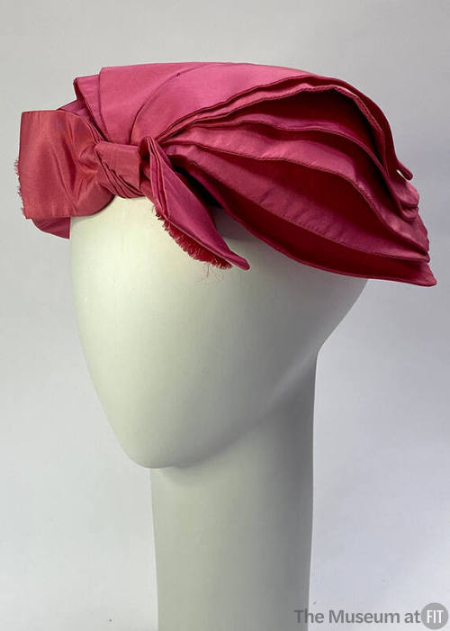 Pink hat with large center bow and petal-like side panels 