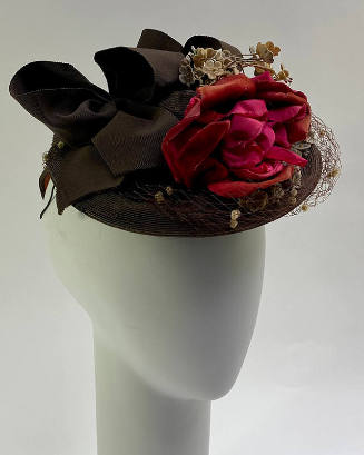 Brown straw hat with large red rose at front surrounded by small blue posies and net with white…