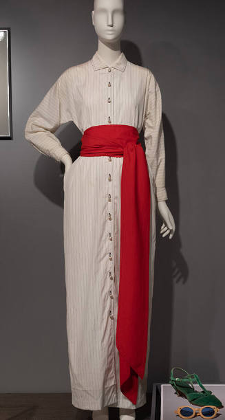 Long, off white button down dress with plack pinstripes and red sash tied at waist