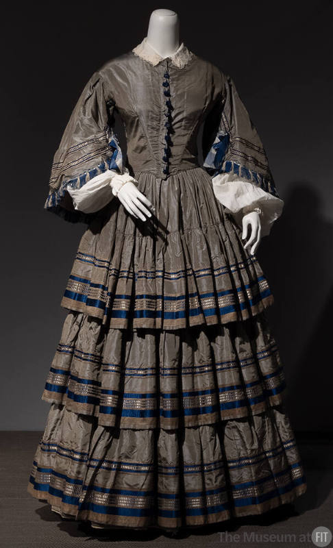 Grey silk taffeta floor length dress with bell sleeves and full pleated skirt with three ruffle…