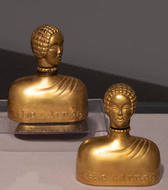 Metallic gold glass perfume bottle in the shape of a female bust