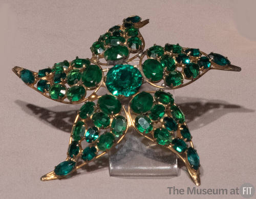 Starfish shaped pin with green stones on gold plated sterling silver setting


