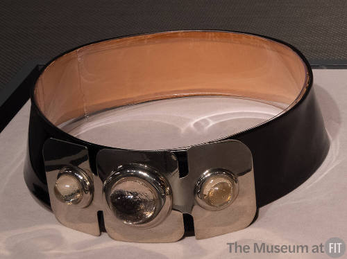 Wide black leather belt with large silvertone metal front plate with three clear stones